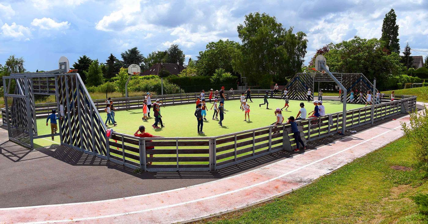 Enfants jouant dans un parc sur un terrain de basket